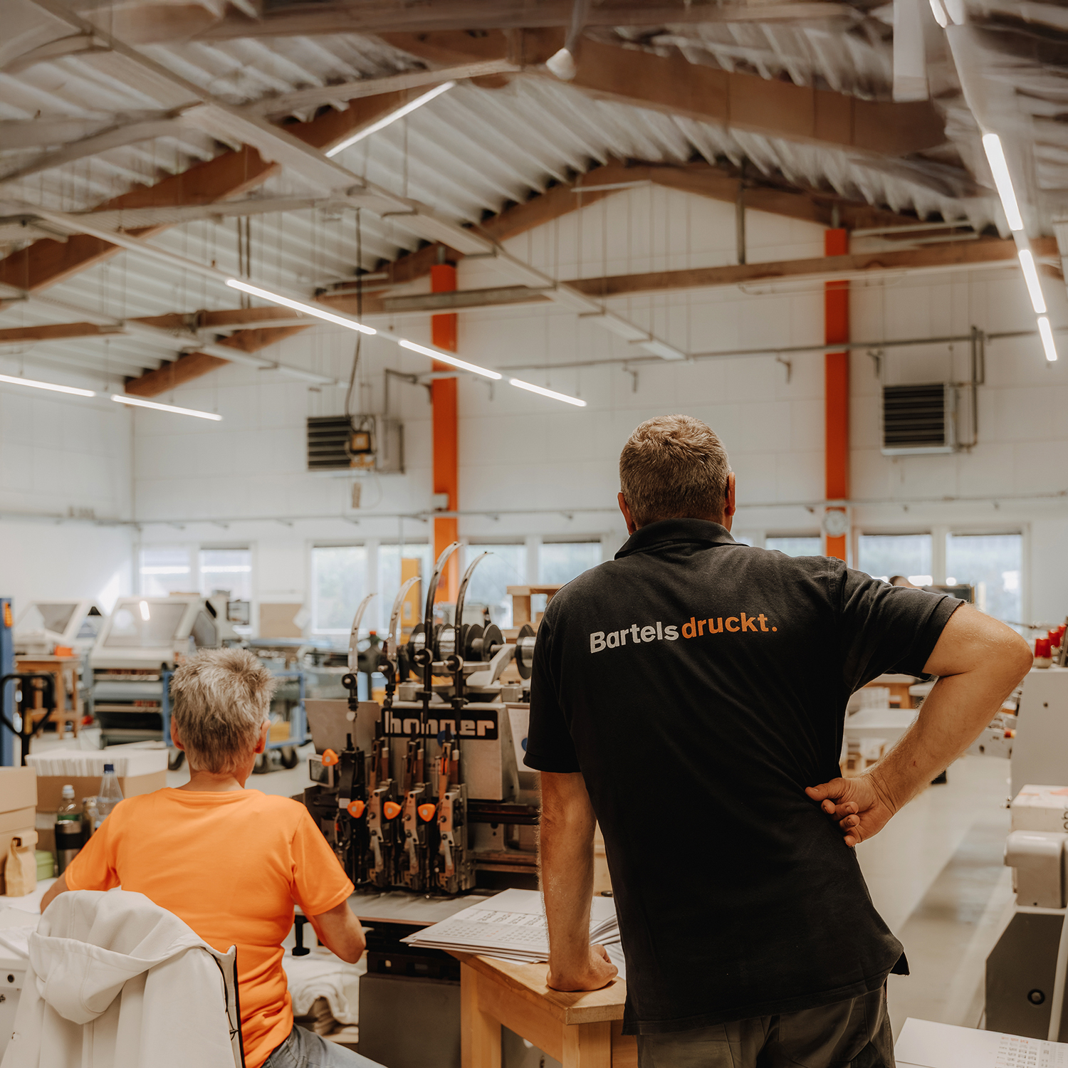 Teamarbeit in der Weiterverarbeitung an einer Falzmaschine bei Bartels Druck